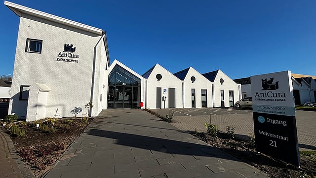 Een wit gebouw met een bord.