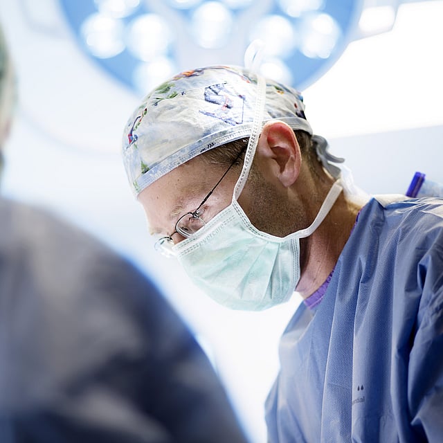Een arts die chirurgische scrubs en masker draagt.