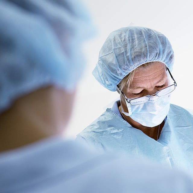 Een persoon die chirurgische scrubs en een masker draagt.