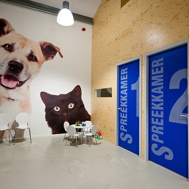 Een kamer met twee deuren en een muurschildering van honden en katten aan de muur.