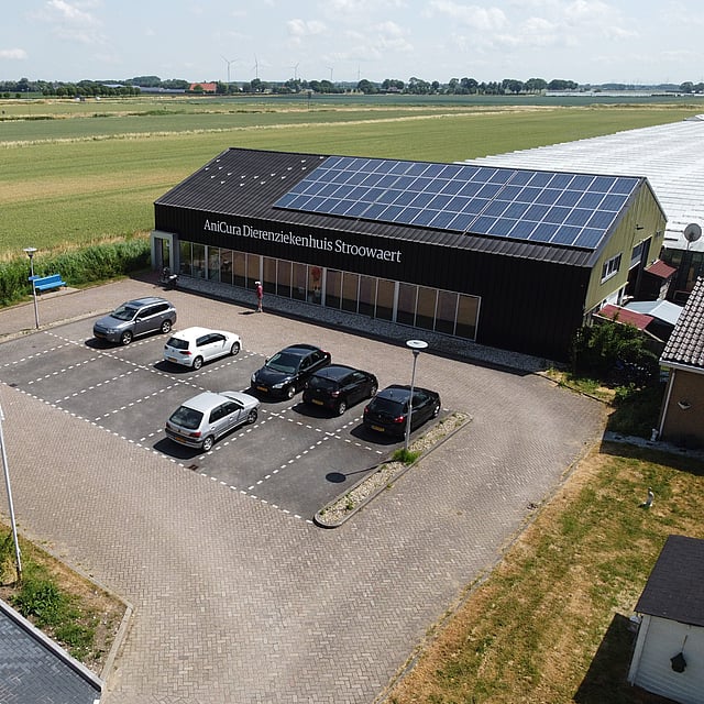 Een parkeerplaats met auto's die voor een gebouw geparkeerd staan.