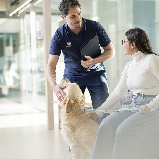 Een persoon en persoon zittend op een bank met een hond.