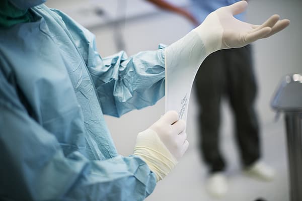 Een persoon die chirurgische handschoenen draagt.