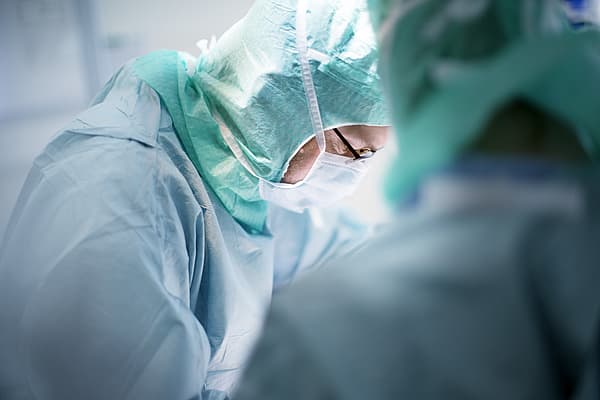 Een close-up van een arts die een masker draagt.