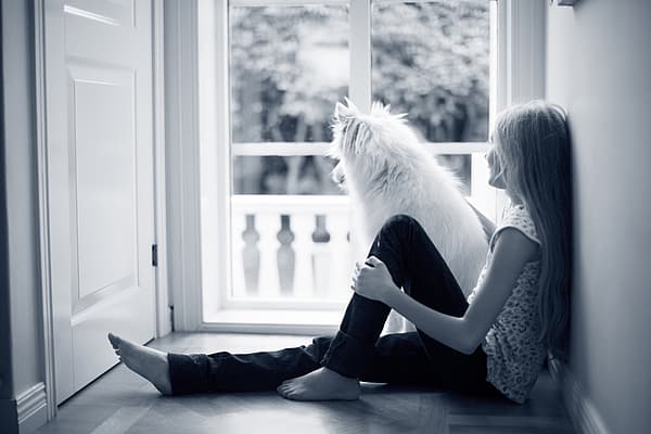 Een kind dat op de grond zit met een hond.