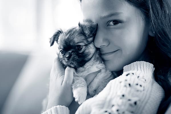 Een kind dat een hond vasthoudt.