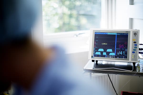Een computerscherm met een blauw scherm en een persoon op de achtergrond.