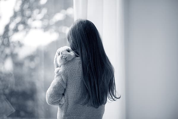 Een persoon die een konijn vasthoudt.