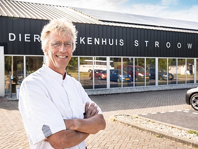 Een persoon die voor een gebouw staat.