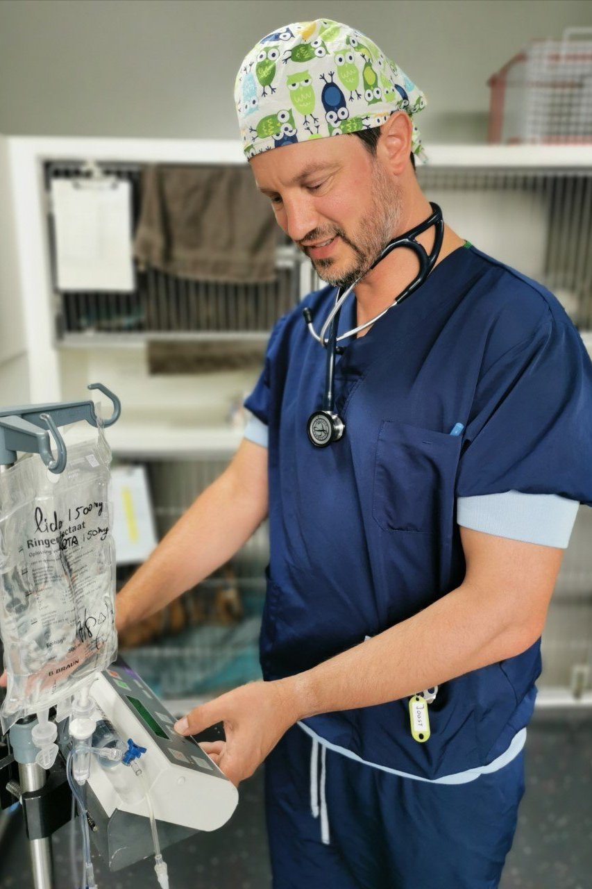 Een persoon in scrubs en een bandana.