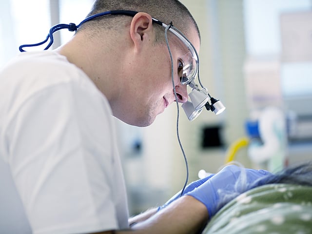 Een persoon die een chirurgisch masker en handschoenen draagt.