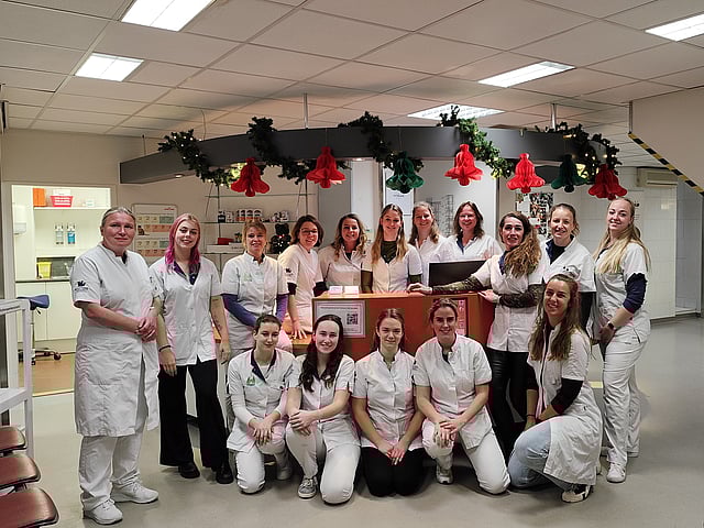 Een groep vrouwen in witte uniformen die voor een foto stellen.