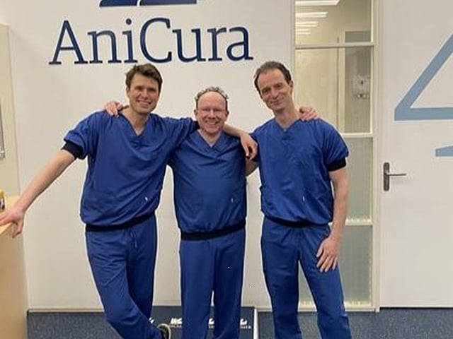 Een groep mannen in blauwe uniformen die voor een foto poseren.