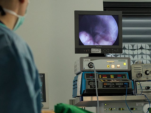 Een persoon in scrubs die een monitor bekijken.