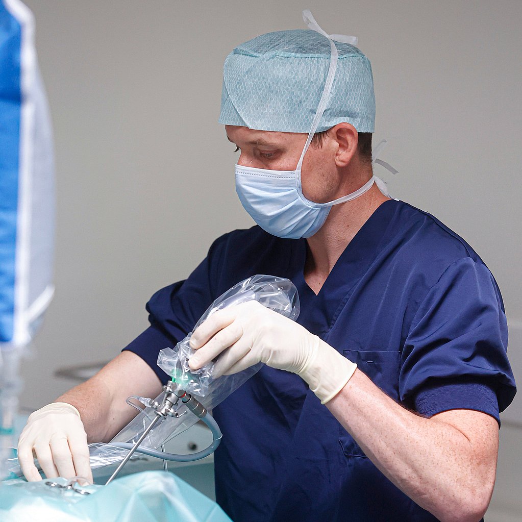 Een arts met een masker en handschoenen.