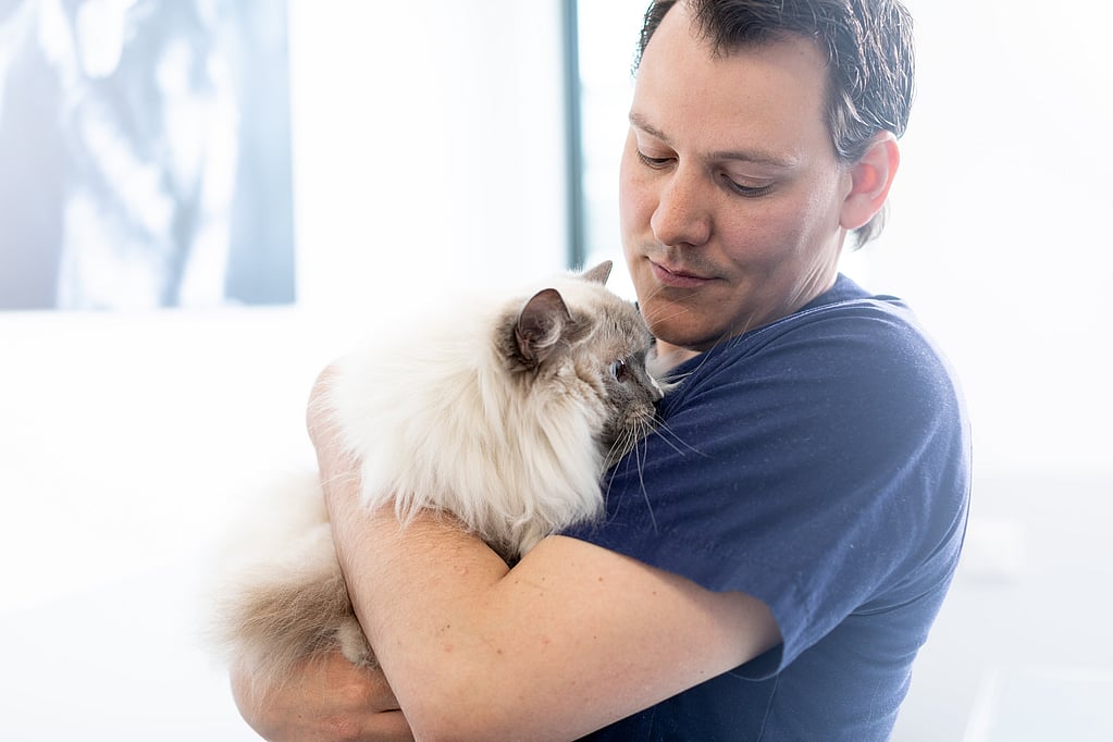 Een persoon die een kat vasthoudt.