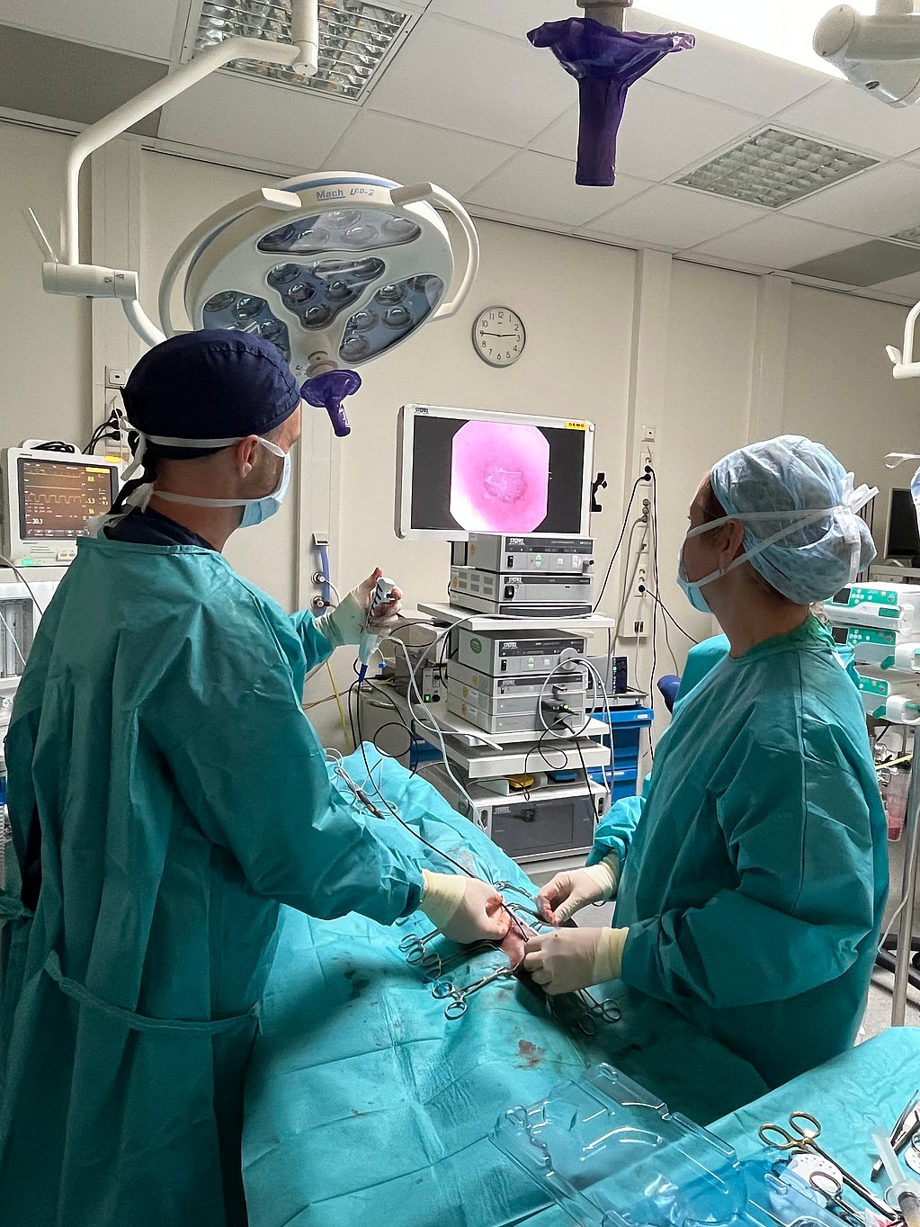 Een groep mensen in scrubs in een operatiekamer.