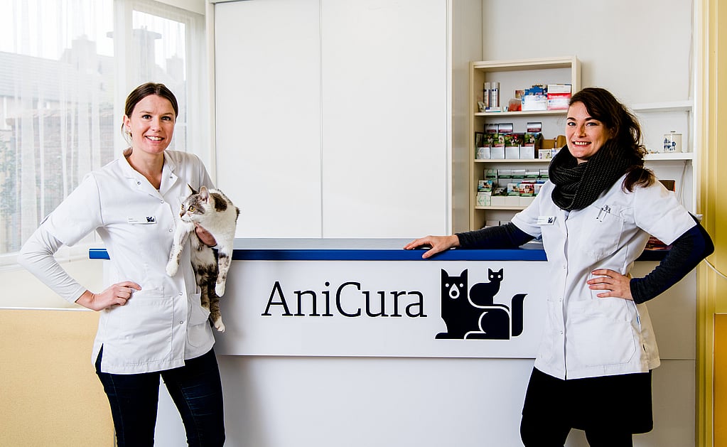 Twee vrouwen in witte jassen die een kat houden.