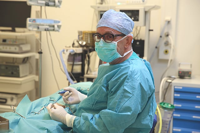 Een persoon in een operatiejas en masker.