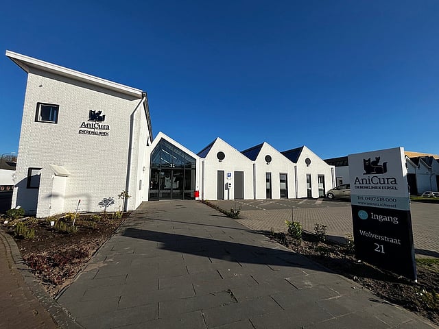 Een wit gebouw met een bord.