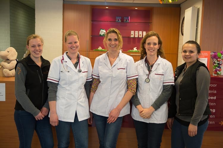 Een groep vrouwen die witte laboratoriumjassen dragen.